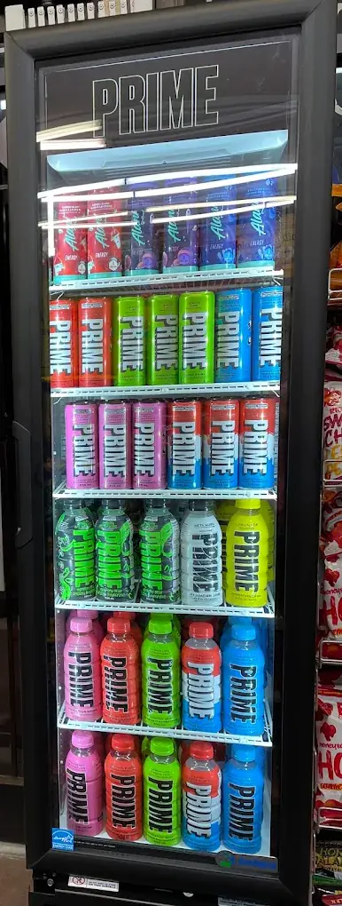 Glass-door drinks cooler at Eagle Mini Mart filled with bottles and cans of sports drinks