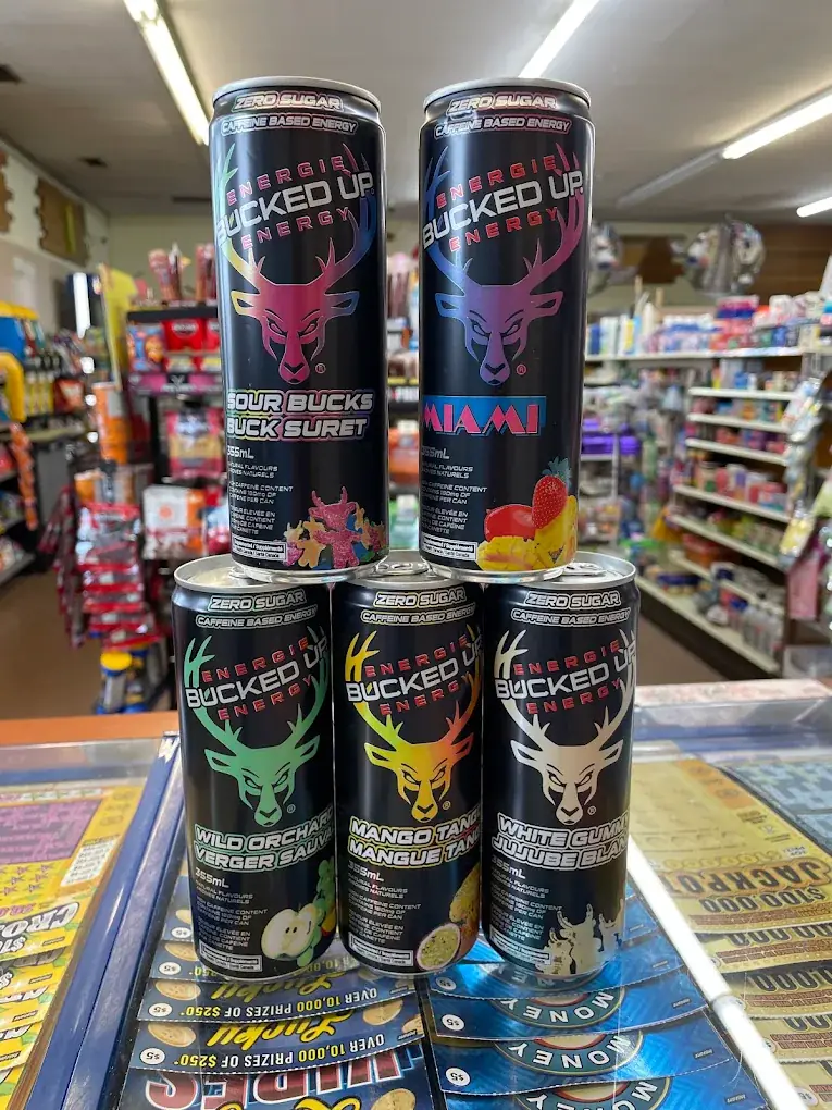Cans of energy drinks stacked on the counter at Eagle Mini Mart, with store shelves behind
